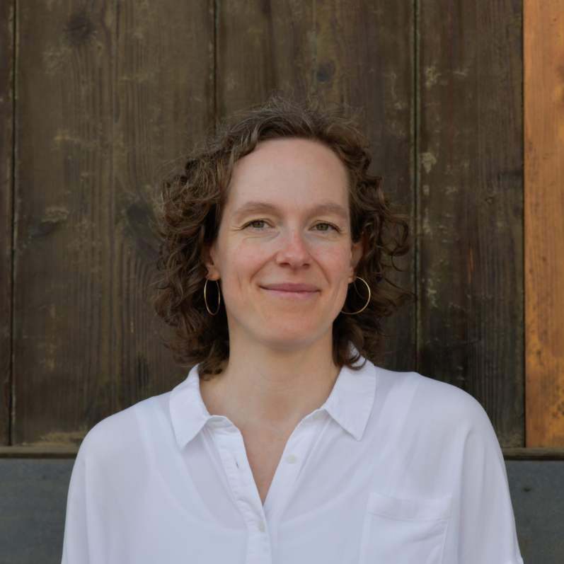 Jennifer Bosch, Coach für Einzelcoaching, Führungskräfteentwicklung und Teamentwicklung, vor einer rustikalen Holztür