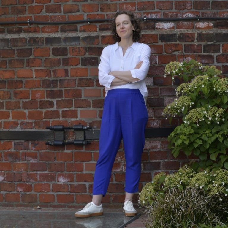 Jennifer Bosch, Business Coach und Expertin für Personalentwicklung, vor einer rustikalen Holztür – mit Gestik im Gespräch