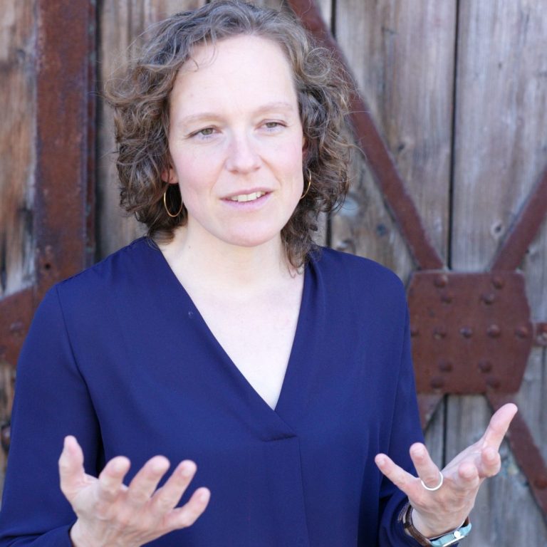 Jennifer Bosch, Business Coach und Expertin für Personalentwicklung, vor einer rustikalen Holztür – mit Gestik im Gespräch